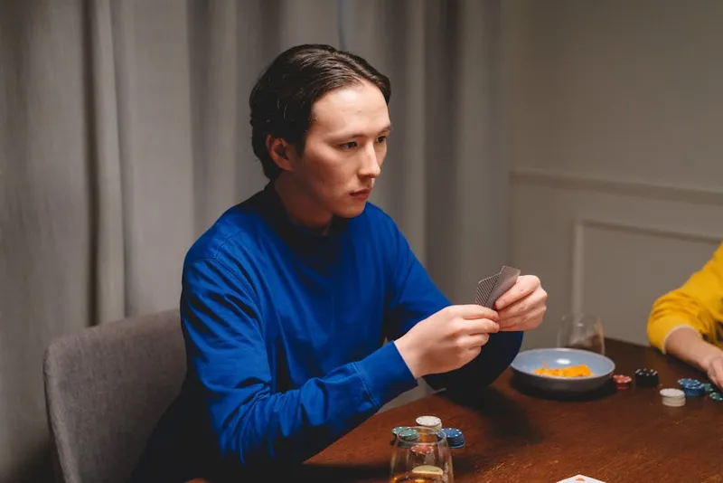 man focused thinking cards table