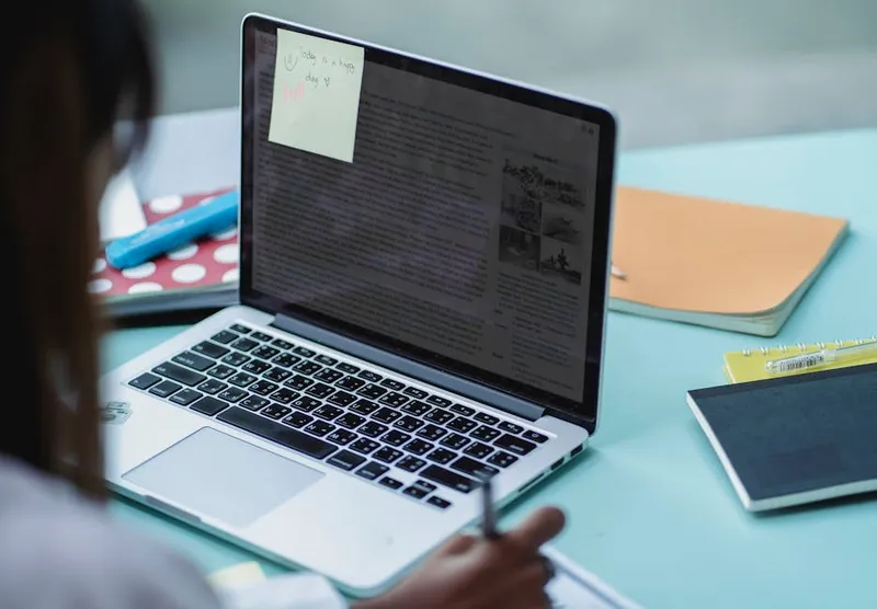 student studying notes laptop