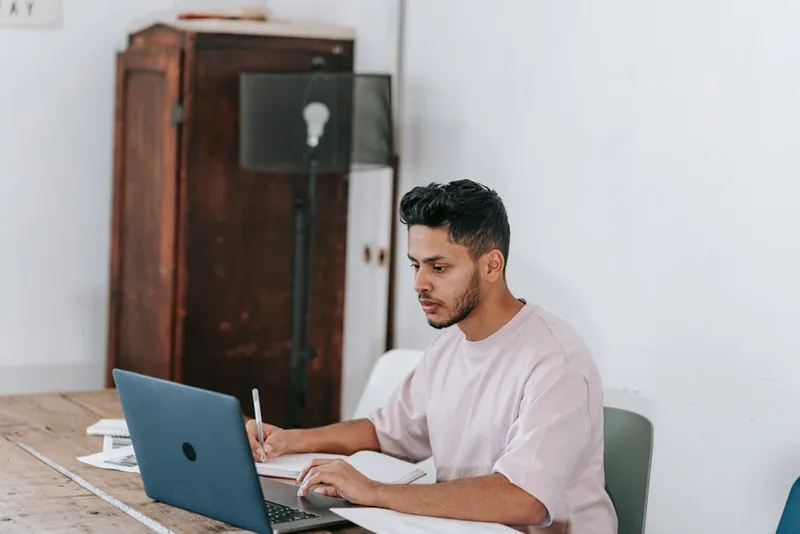 man focused studying notebook desk