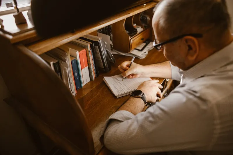 man studying notes desk